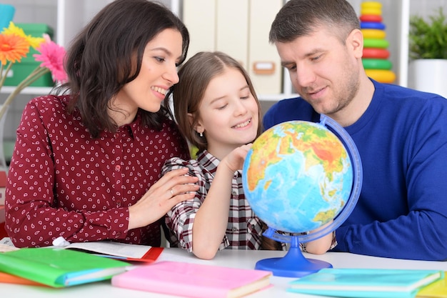 Ritratto di genitori e figlia guardando il globo