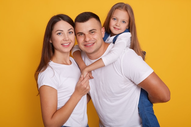 Ritratto di genitori felici, papà porta le loro belle figlie sulla schiena.