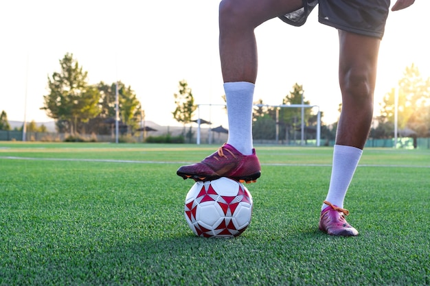 Ritratto di giocatore di football sul campo con il piede sulla palla Giocatore di football maschile con il piede sulla palla sull'erba