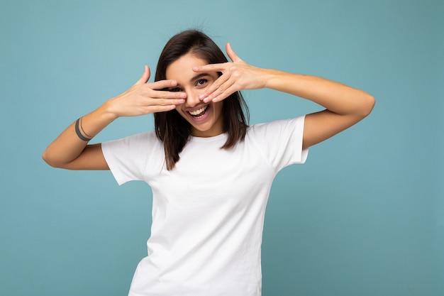 Ritratto di gioiosa e sorridente giovane bella signora bruna con emozioni sincere che indossa casual