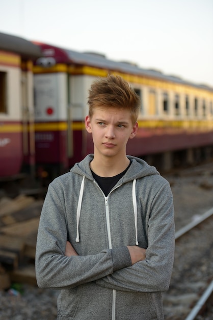 Ritratto di giovane adolescente bello presso la stazione ferroviaria