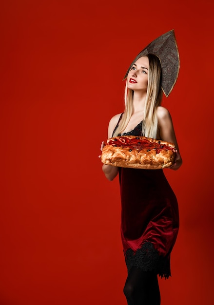 Ritratto di giovane bella bionda che tiene una deliziosa torta di ciliegie fatta in casa