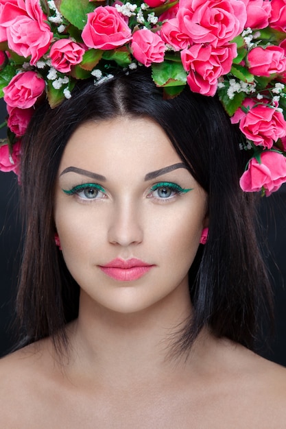 Ritratto di giovane bella bruna con trucco e fiori nei capelli