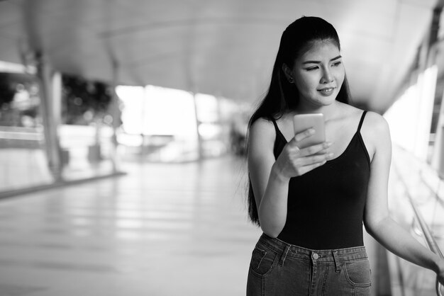 Ritratto di giovane bella donna asiatica che esplora la città in bianco e nero