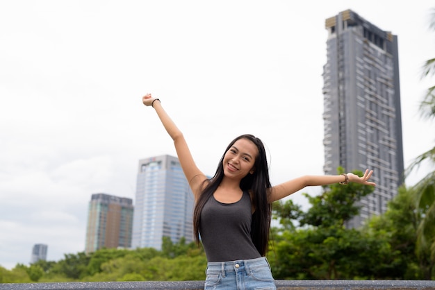 Ritratto di giovane bella donna asiatica che si distende al parco a Bangkok, Tailandia