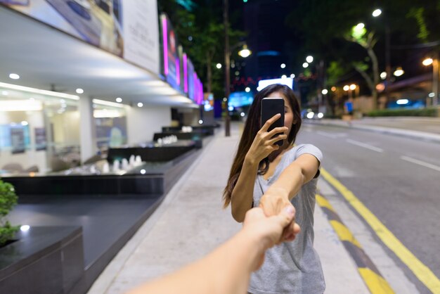 Ritratto di giovane bella donna asiatica che vaga per le strade della città di notte a Kuala Lumpur, Malesia