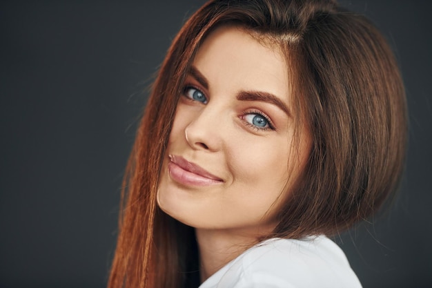 Ritratto di giovane bella donna che posa per la macchina fotografica in studio