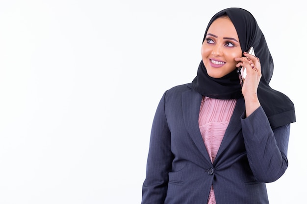 Ritratto di giovane bella donna d'affari musulmana africana che indossa l'hijab isolato contro il muro bianco