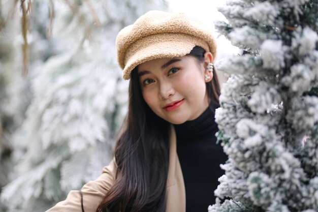 Ritratto di giovane bella donna in abiti invernali nel bosco innevato