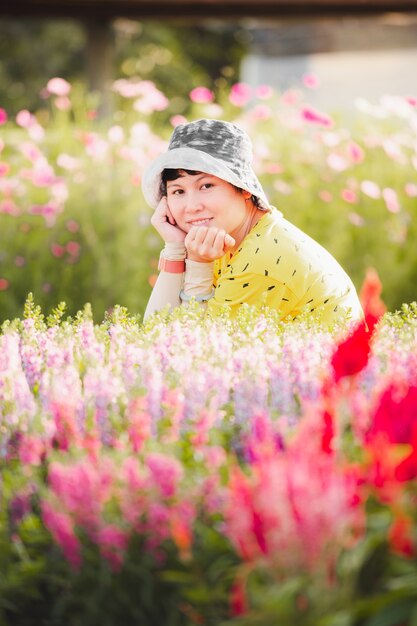 Ritratto di giovane bella donna in posa tra il parco di fiori in fiore.