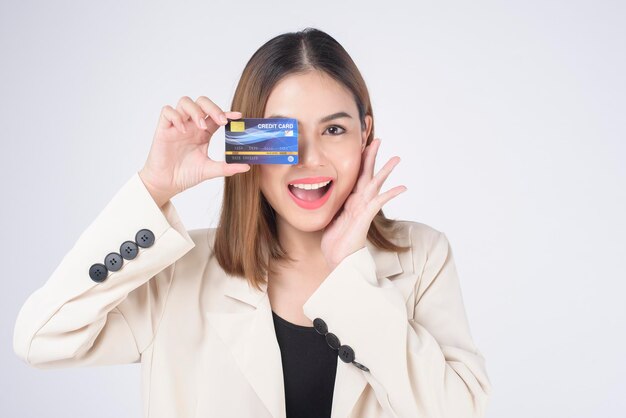 Ritratto di giovane bella donna in tuta in possesso di carta di credito su sfondo bianco in studio