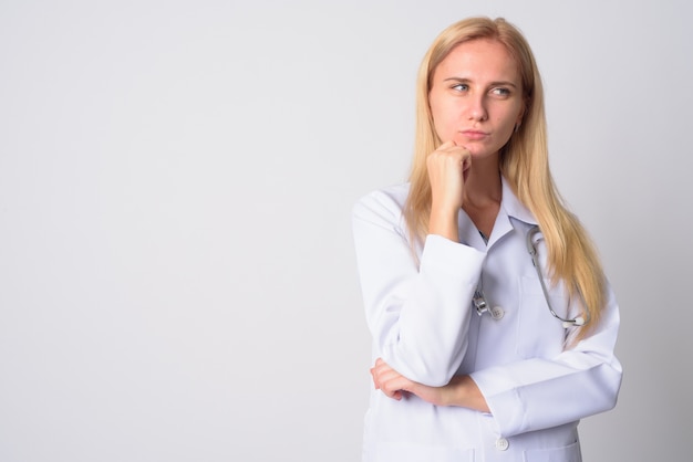 Ritratto di giovane bella donna medico con i capelli biondi su bianco