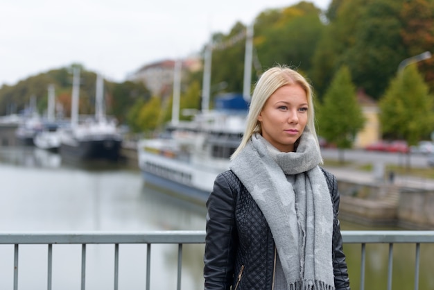 Ritratto di giovane bella donna scandinava bionda rilassante in riva al fiume