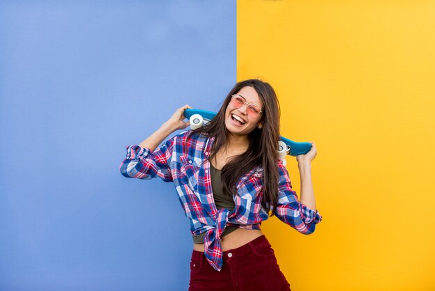 Ritratto di giovane bella ragazza con skateboard