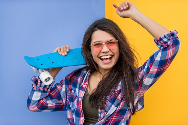 Ritratto di giovane bella ragazza con skateboard