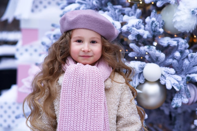 Ritratto di giovane bella ragazza del bambino del bambino nella decorazione di natale al giorno nevoso di inverno vicino