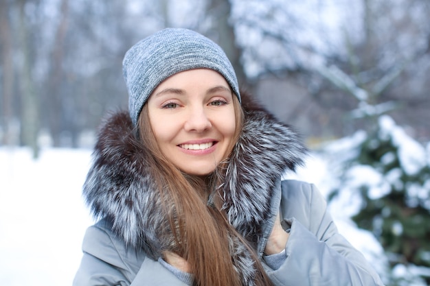 Ritratto di giovane bella ragazza nel parco innevato in vacanza invernale