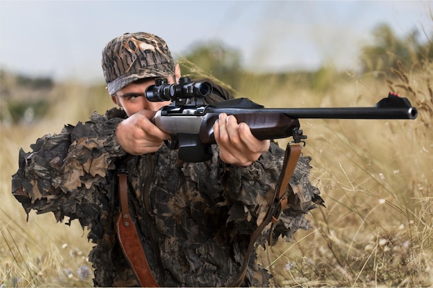 Ritratto di giovane cacciatore con la pistola nella foresta