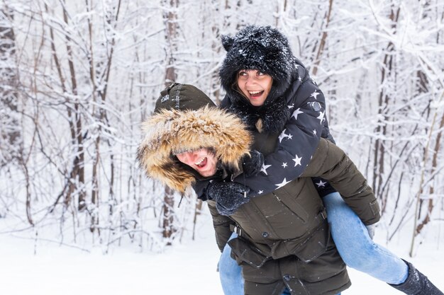 Ritratto di giovane coppia felice a winter park con il loro amico dietro