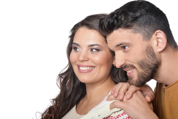 Ritratto di giovane coppia felice sorridente e abbracciando su sfondo bianco