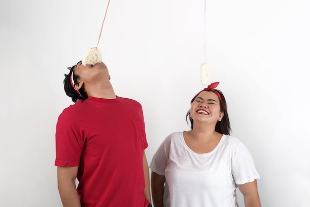 ritratto di giovane coppia indonesiana che mangia cracker durante la celebrazione del giorno dell'indipendenza dell'Indonesia