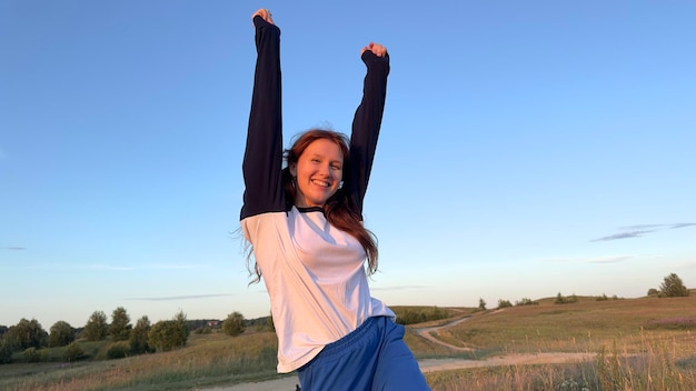 Ritratto di giovane donna adolescente ragazza divertirsi all'aperto in campagna guardando la fotocamera e sorridere