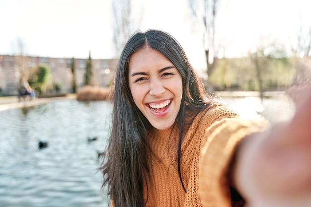 Ritratto di giovane donna affascinante che sorride mentre scatta foto selfie