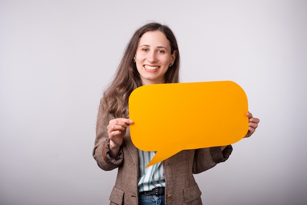 Ritratto di giovane donna affascinante di affari che tiene il fumetto giallo vuoto.