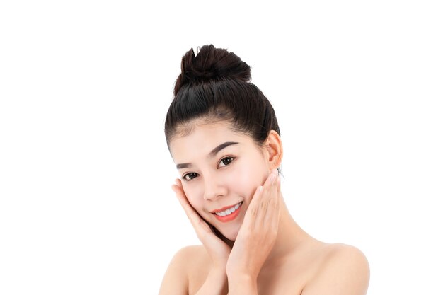 Ritratto di giovane donna asiatica attraente con la pelle e il viso di bellezza isolati su superficie bianca. Concetto di cura di pelle e viso sani.