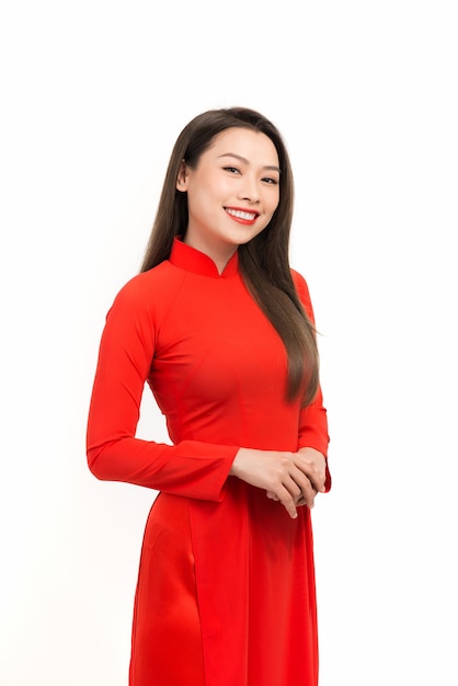 Ritratto di giovane donna asiatica che indossa un rosso ao dai con il bianco.