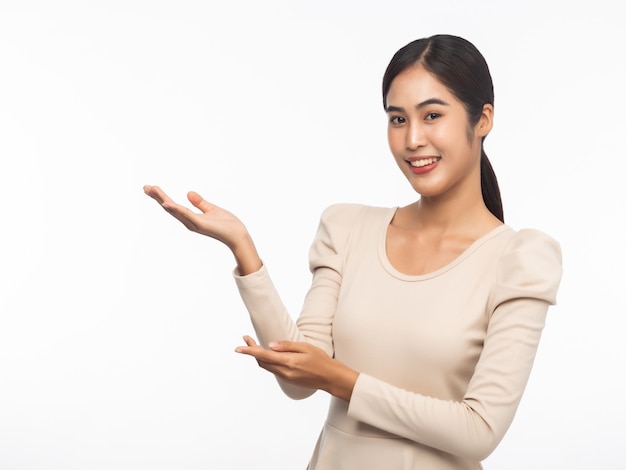 Ritratto di giovane donna asiatica di affari che indica in su isolato su priorità bassa bianca