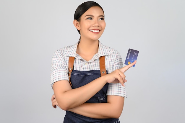 Ritratto di giovane donna asiatica in posa uniforme da cameriera con carta di credito