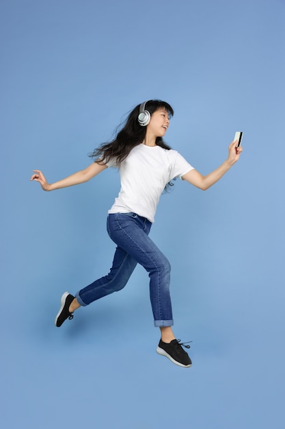 Ritratto di giovane donna asiatica isolata sul fondo blu dello studio