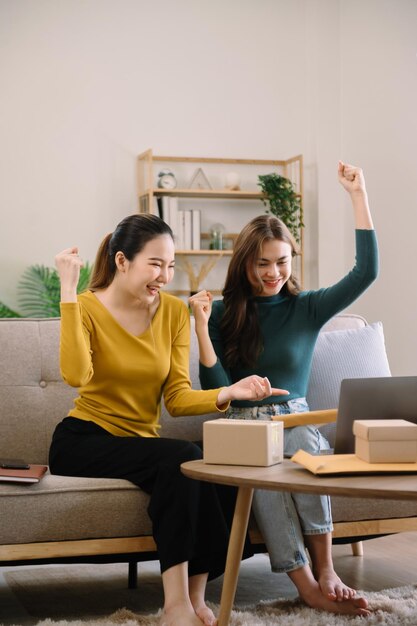 Ritratto di giovane donna asiatica PMI che lavora utilizzando smartphone o tablet ricevendo e controllando l'ordine di acquisto online al concetto di consegna