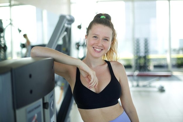 Ritratto di giovane donna atletica in forma in allenatore di fitness trainer palestra