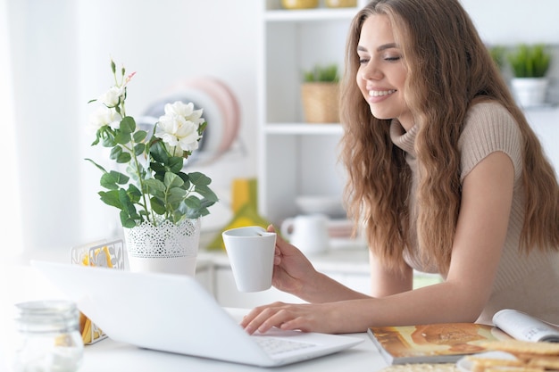 Ritratto di giovane donna attraente che utilizza laptop