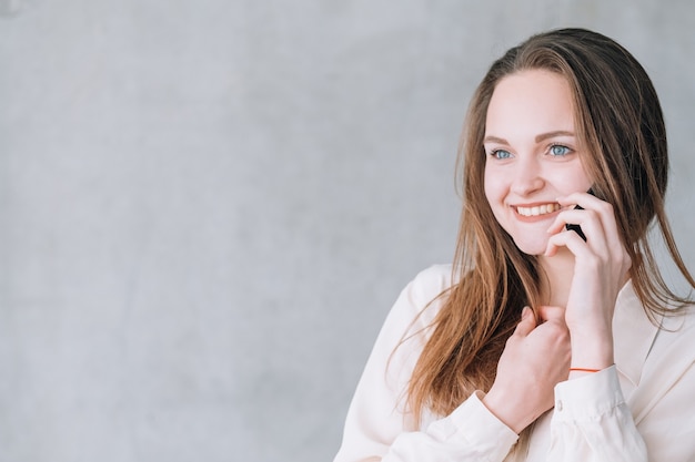 Ritratto di giovane donna. Bella donna eccitata che parla al telefono guardando la pubblicità virtuale