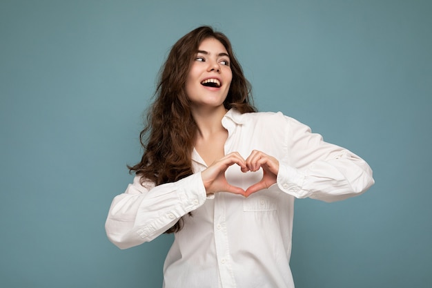 Ritratto di giovane donna castana dai capelli ondulati bella sorpresa felice positiva con le emozioni sincere