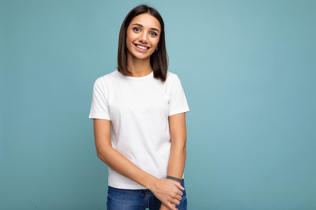 Ritratto di giovane donna castana sorridente alla moda allegra positiva in maglietta bianca casuale