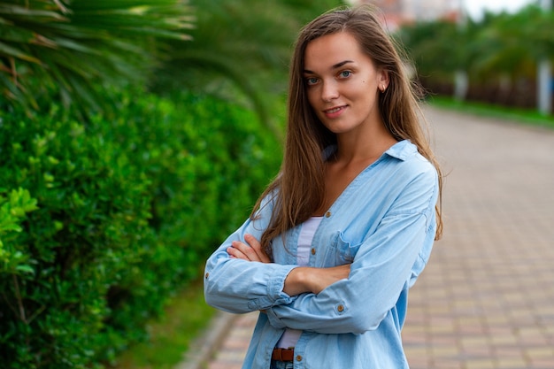 Ritratto di giovane donna casuale attraente che cammina nel parco all'aperto