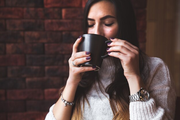 Ritratto di giovane donna che beve caffè