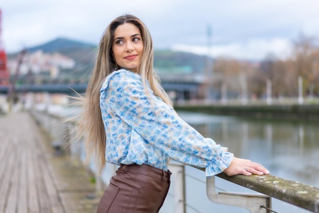 Ritratto di giovane donna che cammina lungo il fiume nel concetto di stile di vita della città