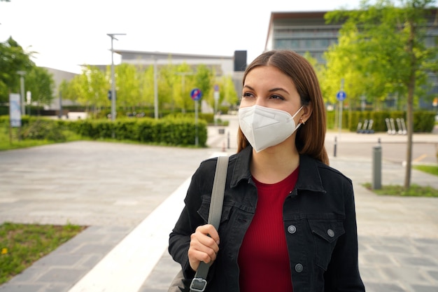 Ritratto di giovane donna che indossa la maschera protettiva FFP2 KN95 che cammina in una strada cittadina