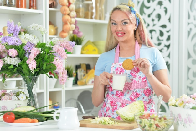 Ritratto di giovane donna che prepara insalata in cucina