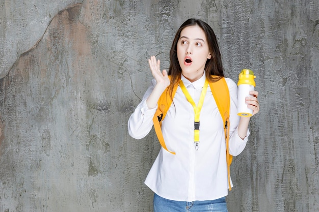 Ritratto di giovane donna che tiene una bottiglia d'acqua. Foto di alta qualità