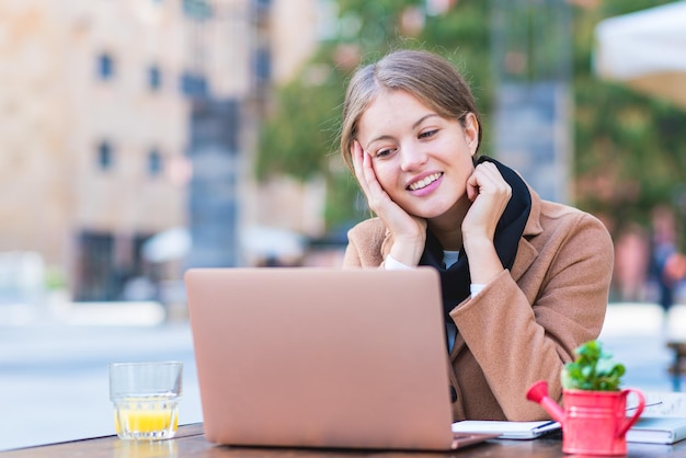 Ritratto di giovane donna d'affari che lavora all'aria aperta, studentessa universitaria usung laptop per l'apprendimento, la comunicazione e lo studio