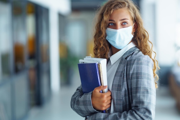 Ritratto di giovane donna d'affari con maschera protettiva in ufficio Imprenditrice femminile COVID 19