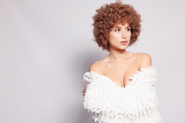 Ritratto di giovane donna di colore sorridente. Ritratto di una giovane e bella donna con taglio di capelli afroamericano e trucco glamour. Colpo dello studio.