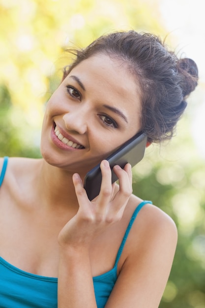 Ritratto di giovane donna divertita che telefona