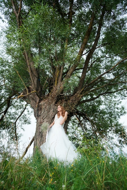 Ritratto di giovane donna graziosa in abito da sposa bianco